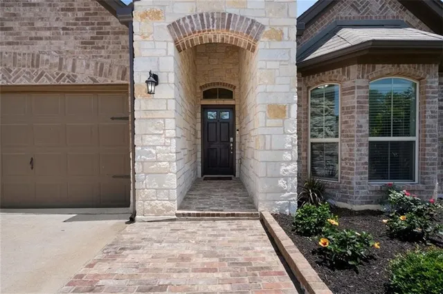 a front view of a house with glass windows and a yard