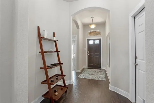 a view of a hallway with wooden floor and stairs