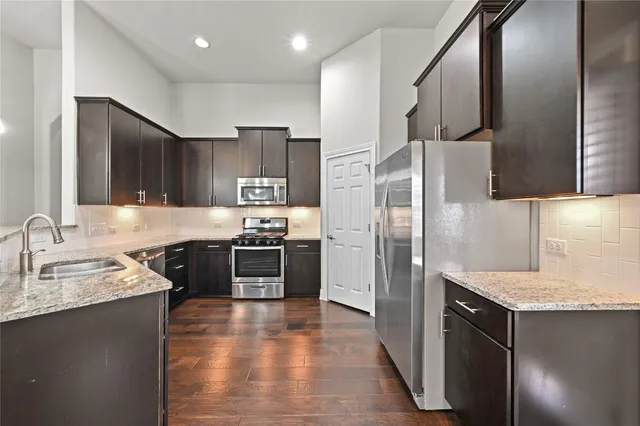 a kitchen with stainless steel appliances granite countertop a refrigerator and a sink