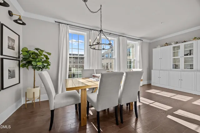 a dining room with furniture potted plants and wooden floor
