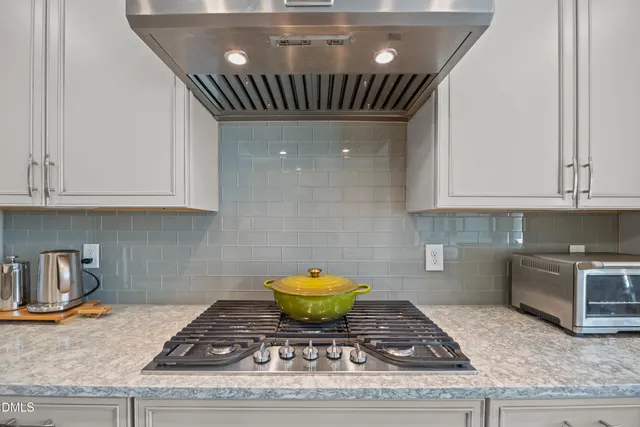 a open kitchen with white cabinets and stainless steel appliances