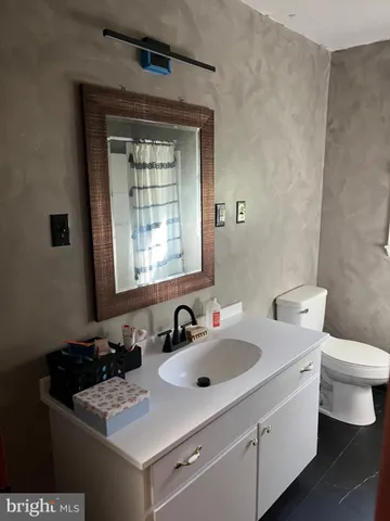 a bathroom with a sink toilet and window