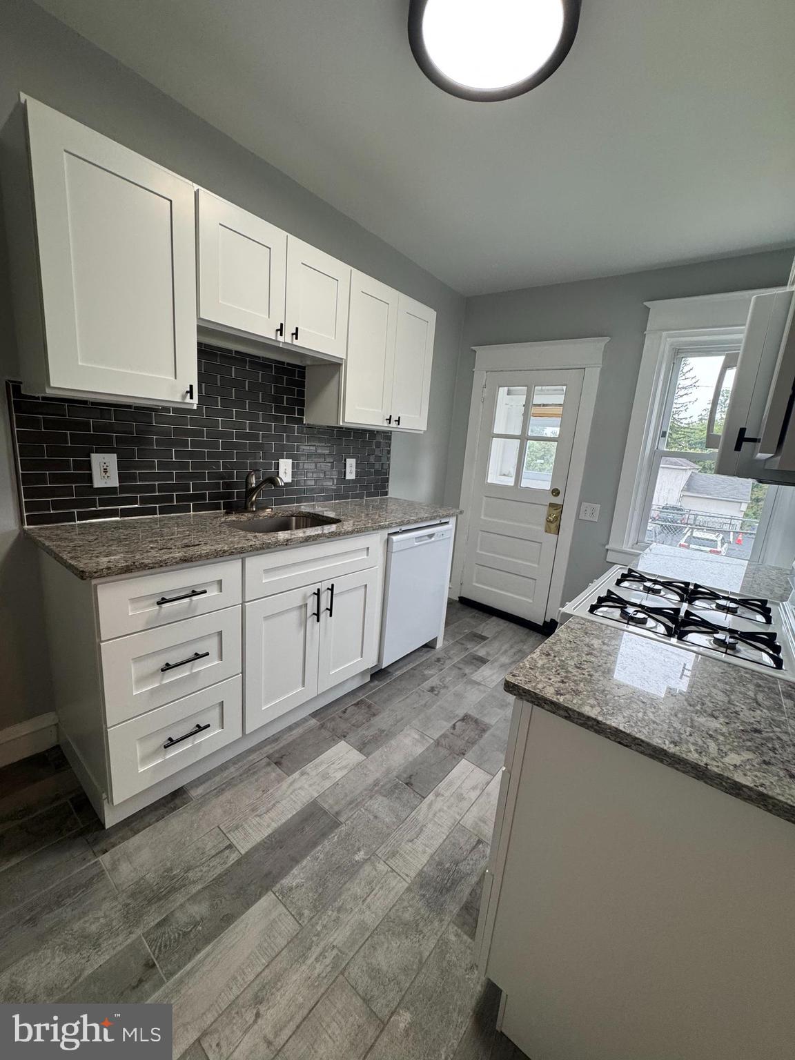 12 West Athens Avenue Ardmore, PA 19003 - Photo 6 of 18 a kitchen with granite countertop a sink a stove and cabinets