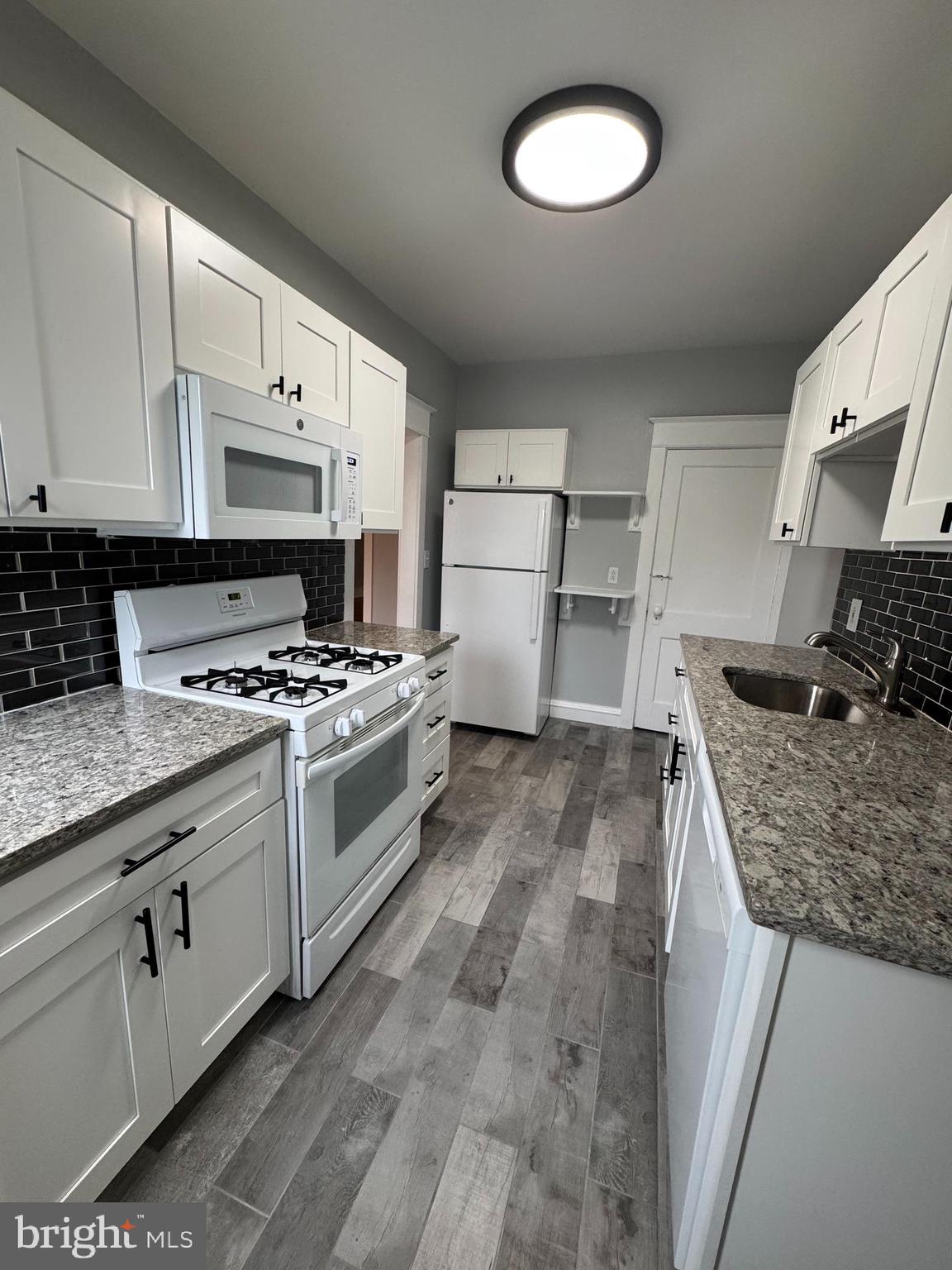 12 West Athens Avenue Ardmore, PA 19003 - Photo 7 of 18 a kitchen with stainless steel appliances granite countertop a stove a sink and a refrigerator