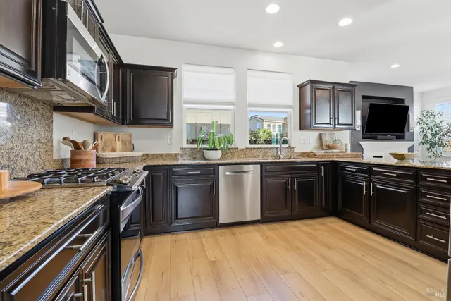 a kitchen with stainless steel appliances granite countertop a refrigerator and a sink