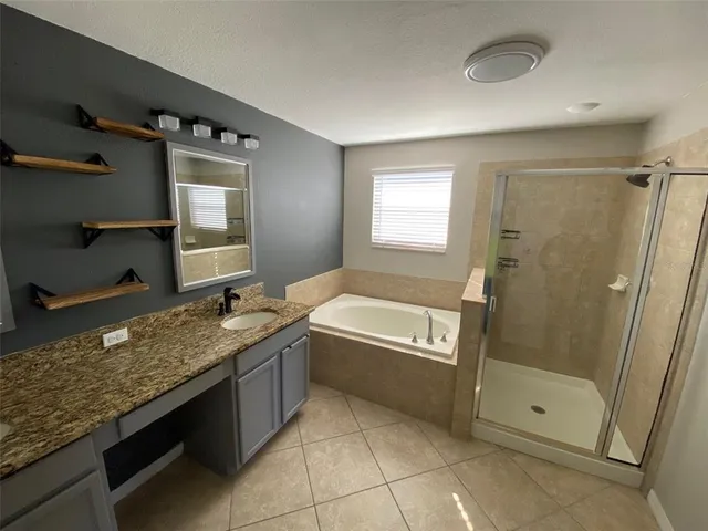 a bathroom with a granite countertop sink a mirror and shower