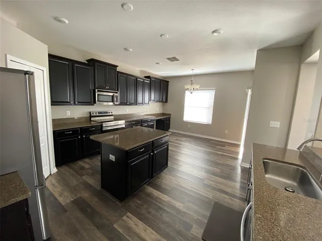 a kitchen with stainless steel appliances granite countertop a stove a refrigerator and a sink