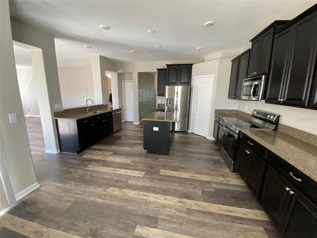 a large kitchen with stainless steel appliances granite countertop a stove a sink and a refrigerator