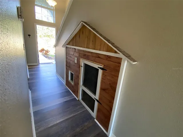 a view of a hallway with wooden floor and staircase