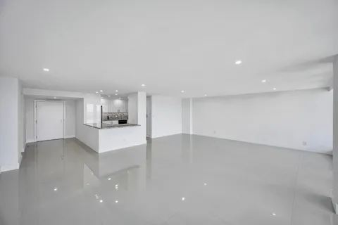 an empty room with kitchen and window