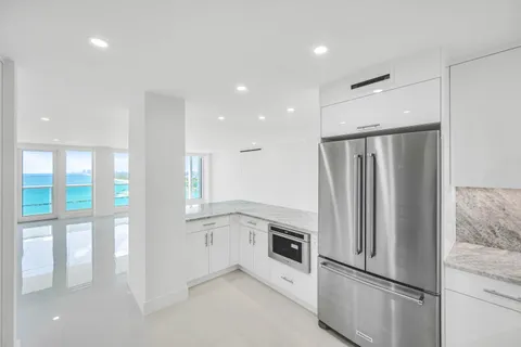 a kitchen with a refrigerator and white cabinets