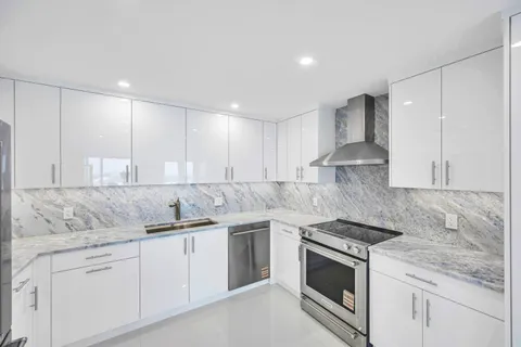 a kitchen with granite countertop white cabinets and white appliances
