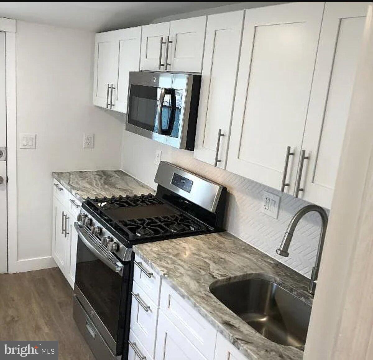 5 Coates Street Bridgeport, PA 19405 - Photo 4 of 28 a kitchen with granite countertop a stove and a sink