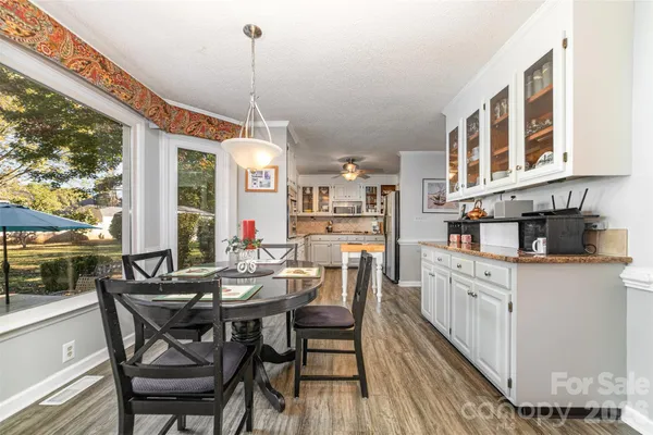 a dining room with furniture a chandelier and wooden floor