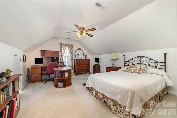 a bedroom with bed and a chandelier