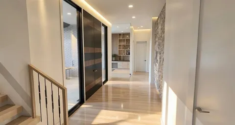 a view of a hallway with wooden floor and windows