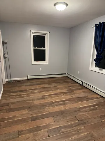 a view of a livingroom with wooden floor and a window
