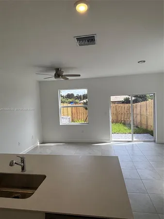 a view of an empty room with window and cabinet