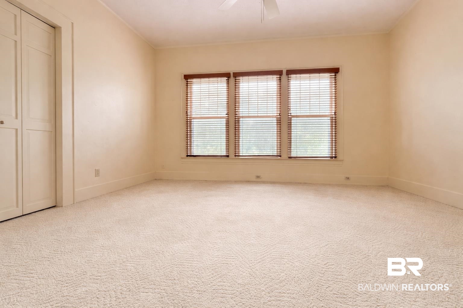 423 Evergreen Avenue Brewton, AL 36426 - Photo 10 of 18 Unfurnished bedroom featuring light carpet, a ceiling fan, and a closet