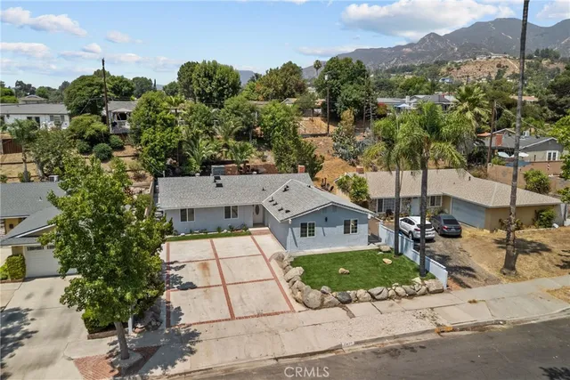 an aerial view of a house with a garden and mountains