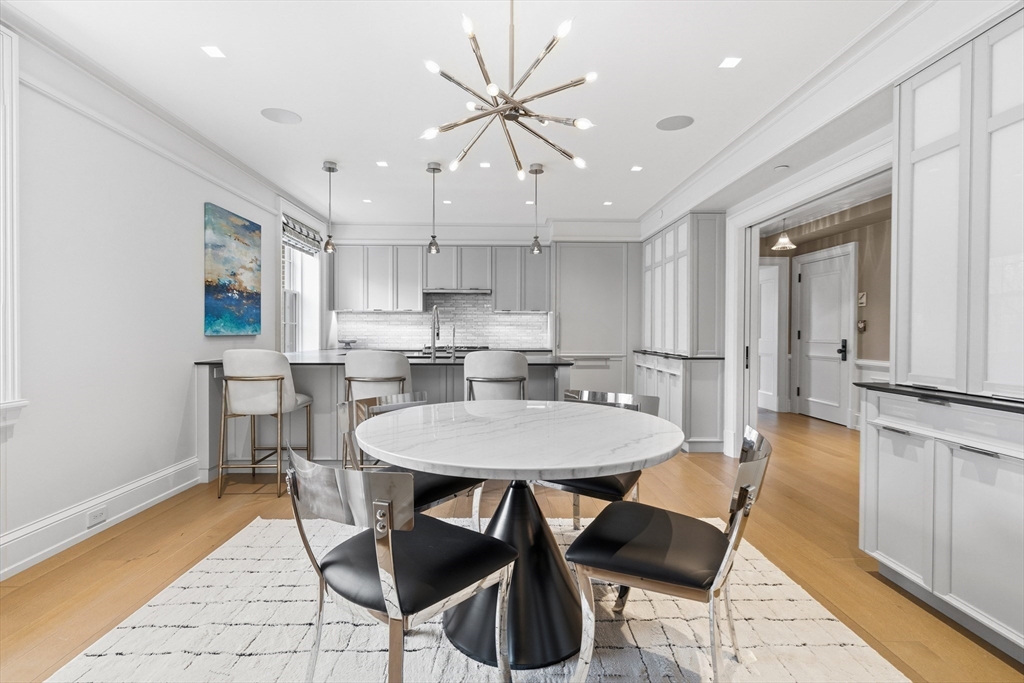 25 Beacon Street, Unit 4 Boston, MA 02108 - Photo 12 of 41 a kitchen with stainless steel appliances kitchen island granite countertop a dining table chairs and a refrigerator