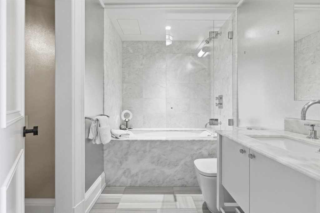 25 Beacon Street, Unit 4 Boston, MA 02108 - Photo 29 of 41 a bathroom with a granite countertop bathtub shower sink and mirror