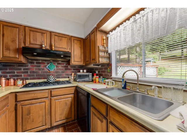 a kitchen view with stainless steel appliances granite countertop a refrigerator and a sink