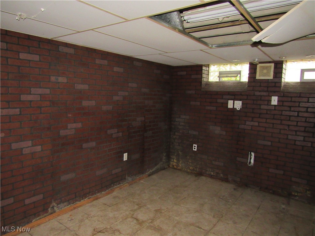 4550 Effie Road Cleveland, OH 44105 - Photo 22 of 29 Basement featuring a paneled ceiling and brick wall