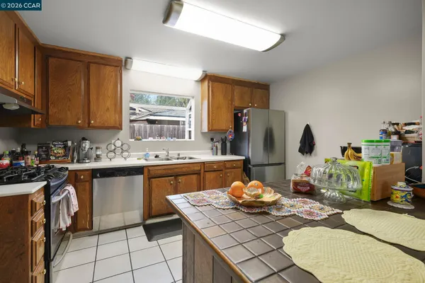 a kitchen with stainless steel appliances kitchen island granite countertop a sink stove and refrigerator