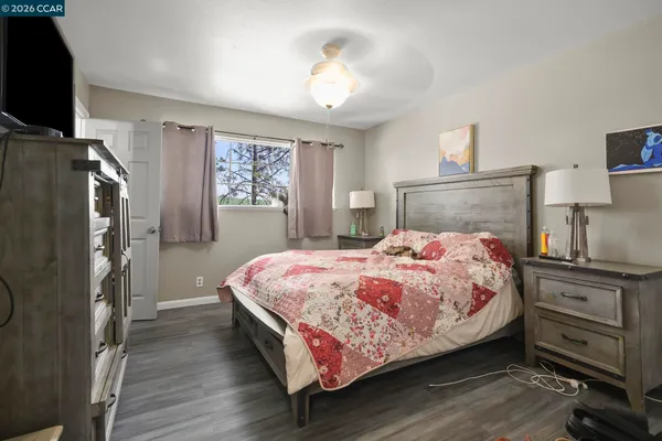 a bedroom with a bed dresser and a flat tv screen