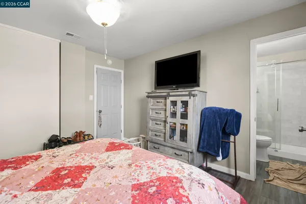 a bedroom with a bed a television and a chair