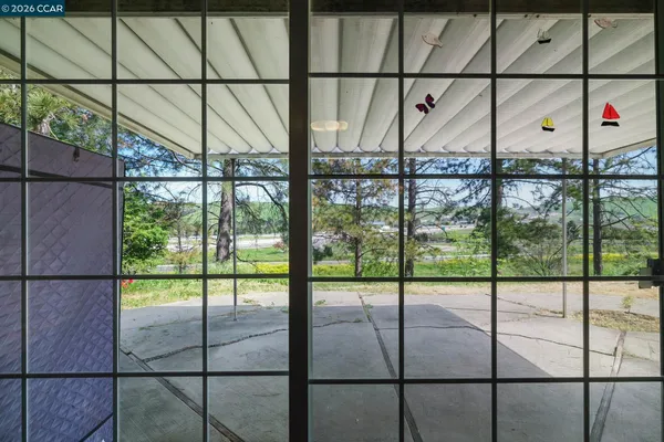 a view of a house with a yard and potted plants