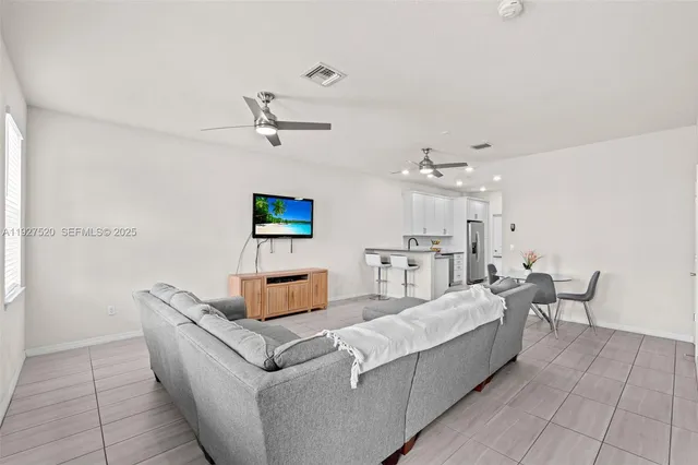 a living room with furniture and a ceiling fan