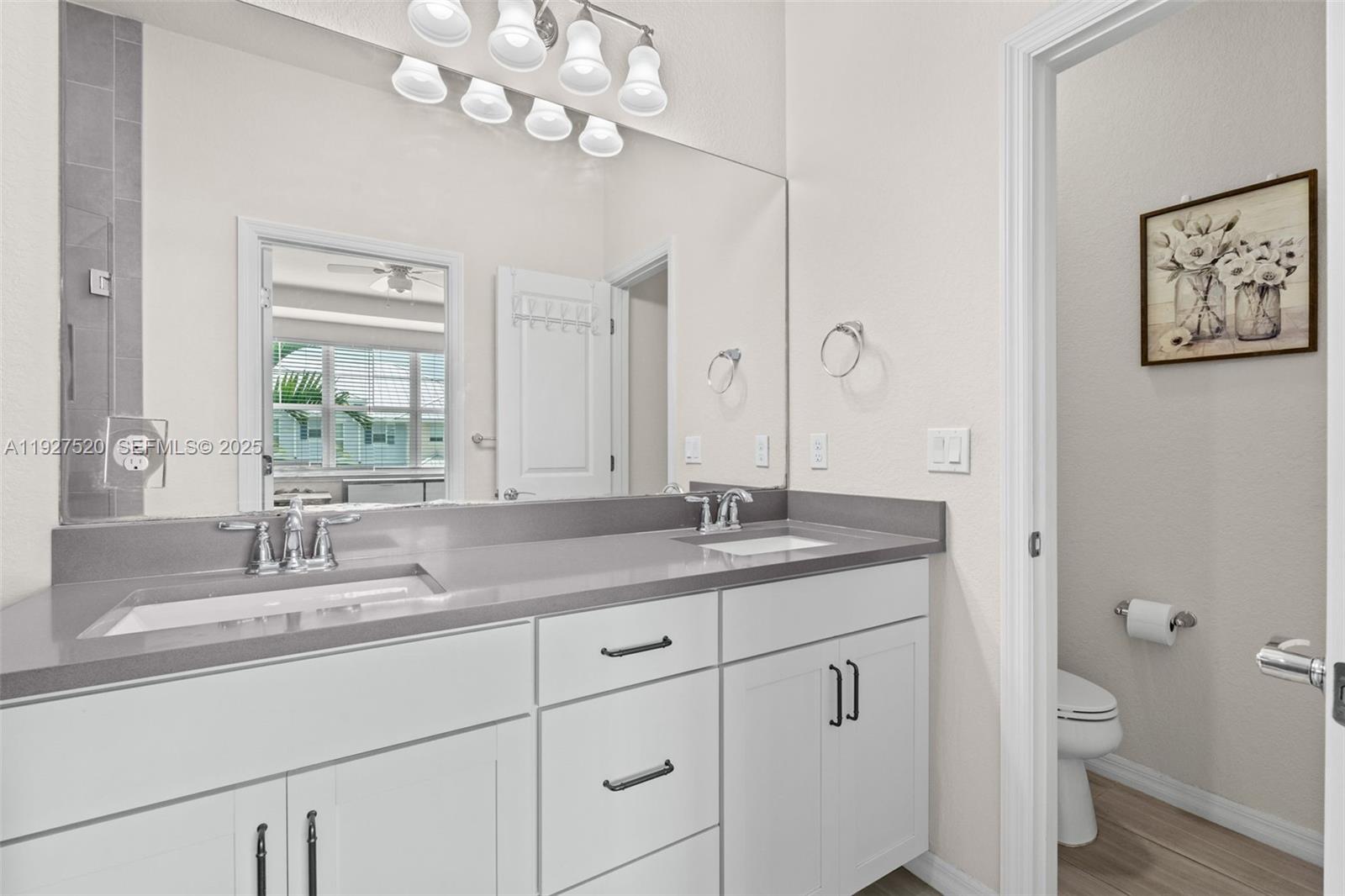 1190 Eucalyptus Drive, Unit 5 Hollywood, FL 33021 - Photo 23 of 42 a bathroom with a granite countertop sink a mirror and a toilet