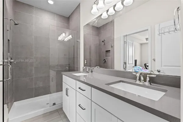 a bathroom with a sink double vanity granite tub and shower