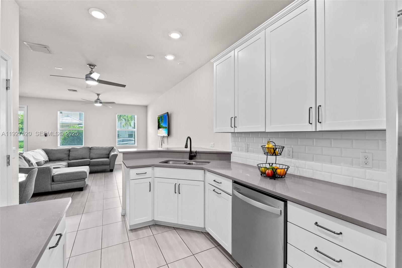 1190 Eucalyptus Drive, Unit 5 Hollywood, FL 33021 - Photo 4 of 42 a kitchen with a sink dishwasher and white cabinets with wooden floor