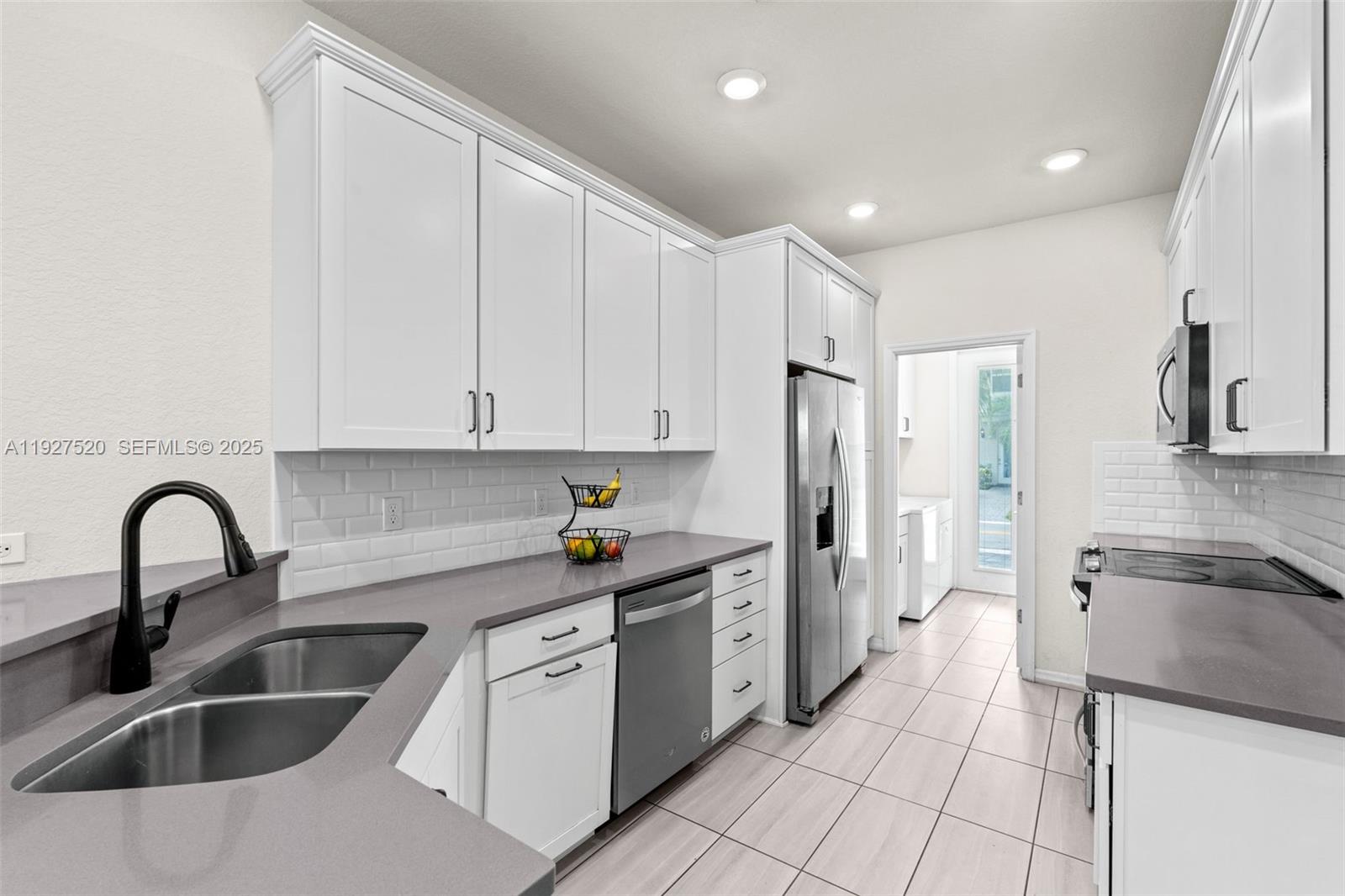 1190 Eucalyptus Drive, Unit 5 Hollywood, FL 33021 - Photo 5 of 42 a kitchen with granite countertop a sink stainless steel appliances and cabinets