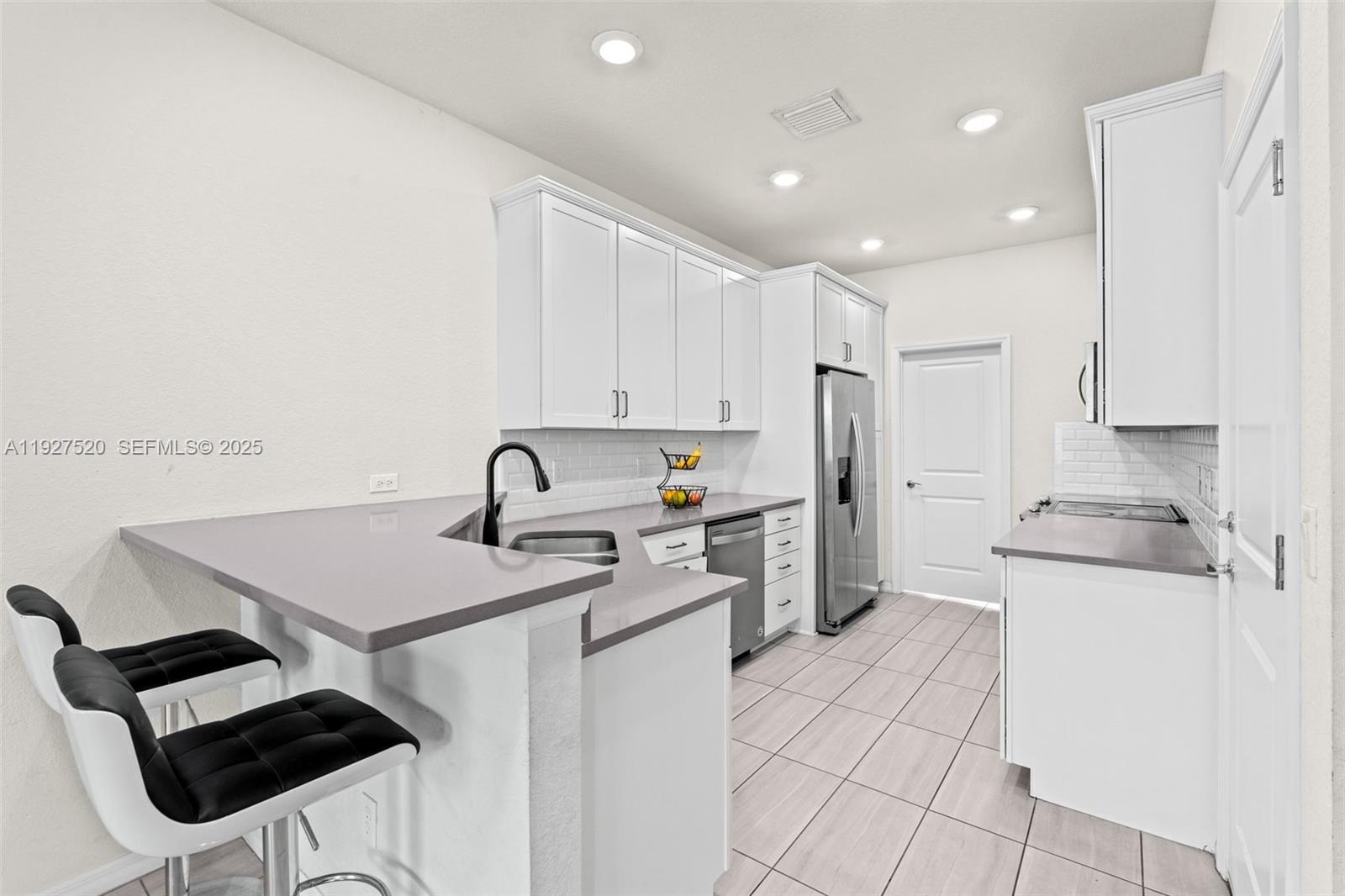 1190 Eucalyptus Drive, Unit 5 Hollywood, FL 33021 - Photo 7 of 42 a kitchen with a sink a stove a refrigerator and white cabinets