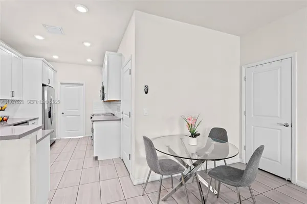 a kitchen with stainless steel appliances kitchen island granite countertop a refrigerator and a stove top oven