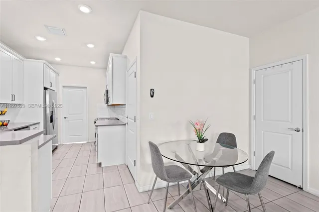 a kitchen with stainless steel appliances kitchen island granite countertop a refrigerator and a stove top oven