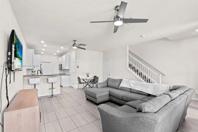 a living room with furniture and kitchen view