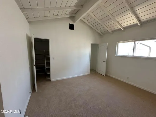 an empty room with a window and a ceiling fan