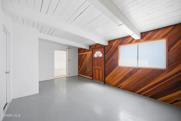 a view of a roof deck with two couches and wooden floor