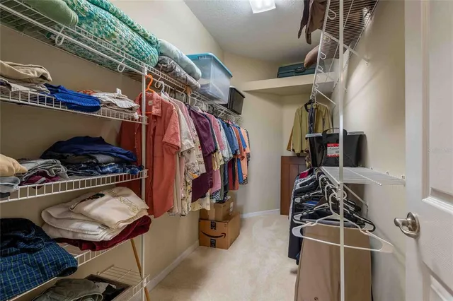 a view of walk in closet with clothes and shoes
