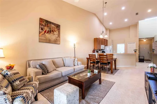 a living room with furniture and a dining table with rug