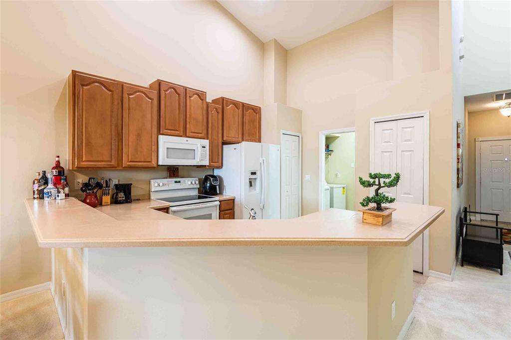 2735 Rutledge Court Winter Haven, FL 33884 - Photo 7 of 42 a kitchen with stainless steel appliances a stove a sink a refrigerator a microwave and cabinets
