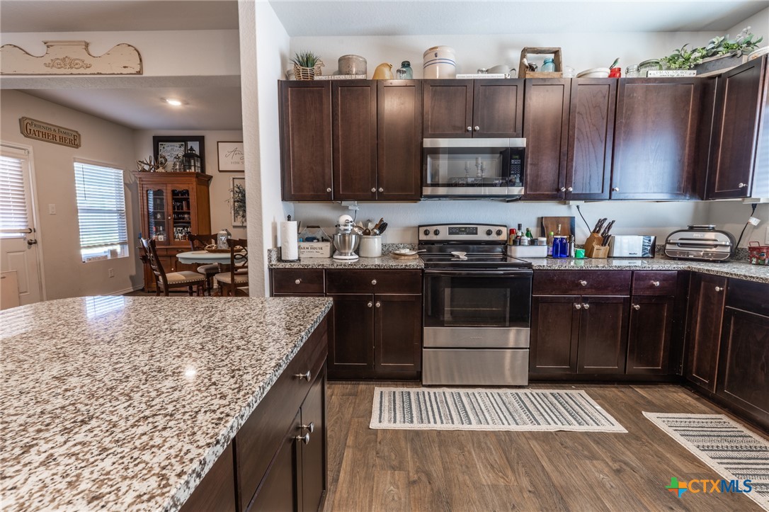 929 Indigo Way Seguin, TX 78155 - Photo 11 of 37 a kitchen with stainless steel appliances granite countertop a stove a sink and a microwave