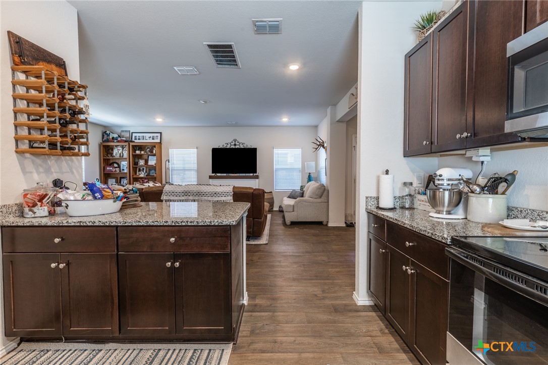 929 Indigo Way Seguin, TX 78155 - Photo 12 of 37 a kitchen with stainless steel appliances kitchen island granite countertop a sink and cabinets