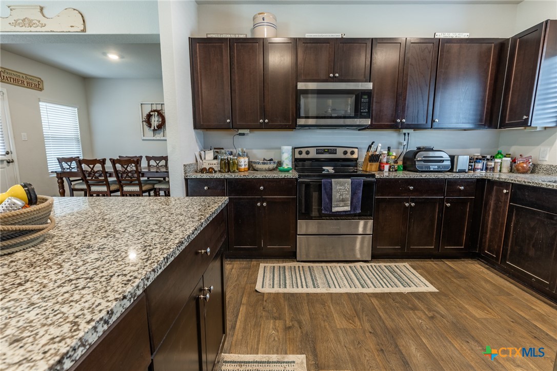 929 Indigo Way Seguin, TX 78155 - Photo 14 of 30 a kitchen with granite countertop wooden cabinets and a granite counter tops