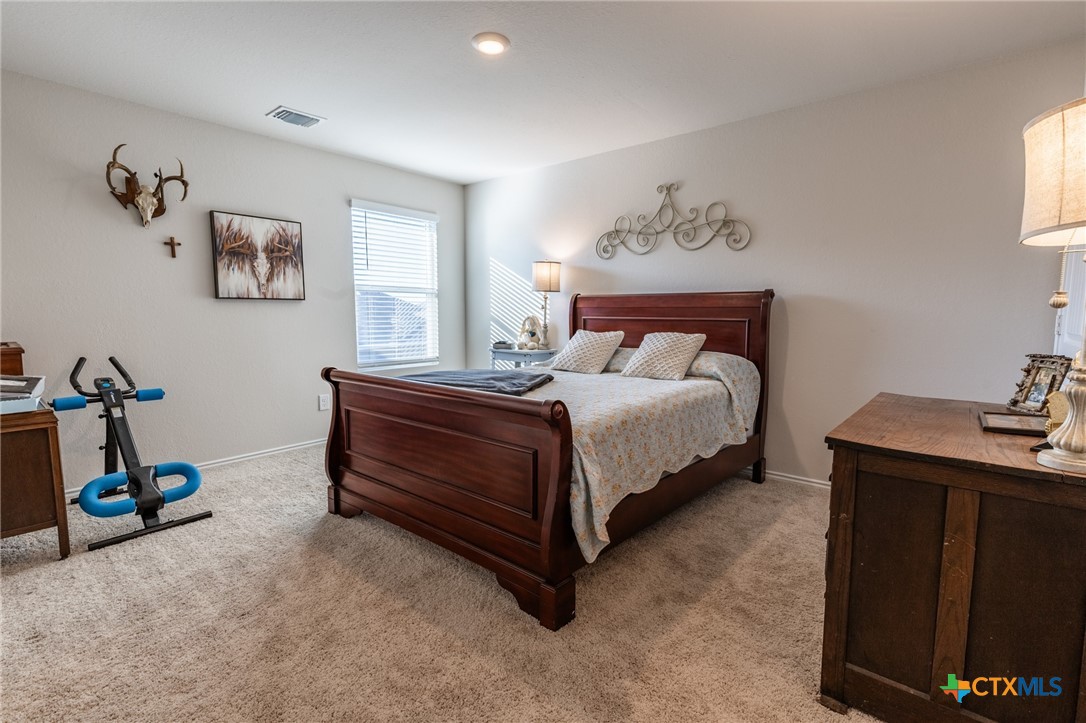 929 Indigo Way Seguin, TX 78155 - Photo 17 of 30 a bed room with a bed and a desk